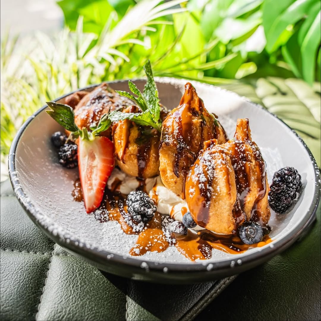 Fried pastry dessert with chocolate, berries, and mint